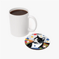 Pop Art-style cat illustration coaster next to a white mug, featuring vibrant geometric shapes and a black-and-white cat.