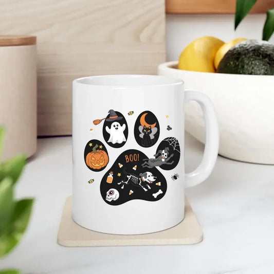 Personalized Halloween ceramic mug with black cat, ghost, pumpkin, and skeleton designs on a kitchen counter.