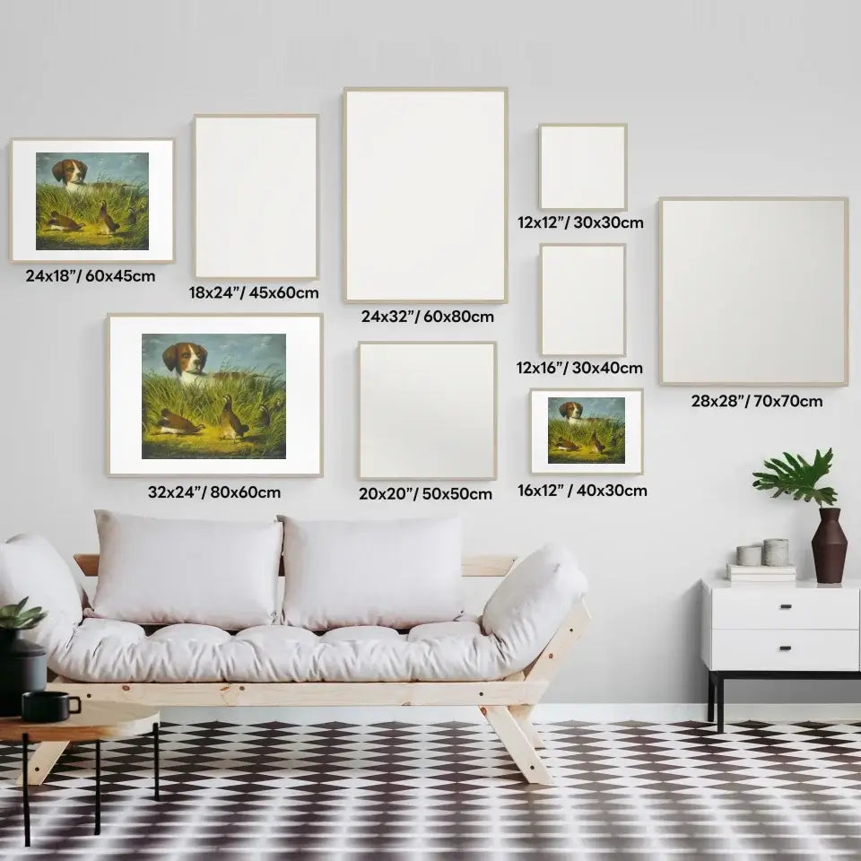 Art gallery wall display featuring classic hunting dog art prints in various sizes and white frames, with sofa and plant decor.