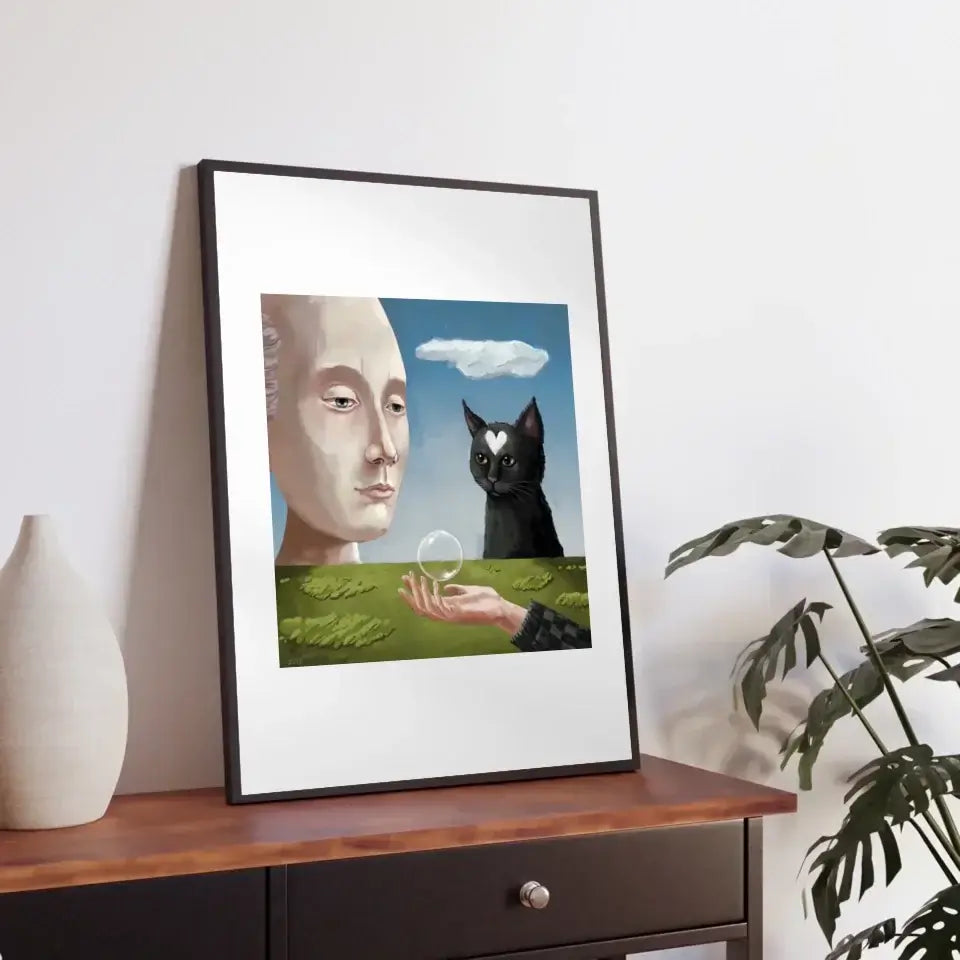 Cat's Philosophical View art print featuring a cat, human face, and nature scene in a framed artwork on a table.