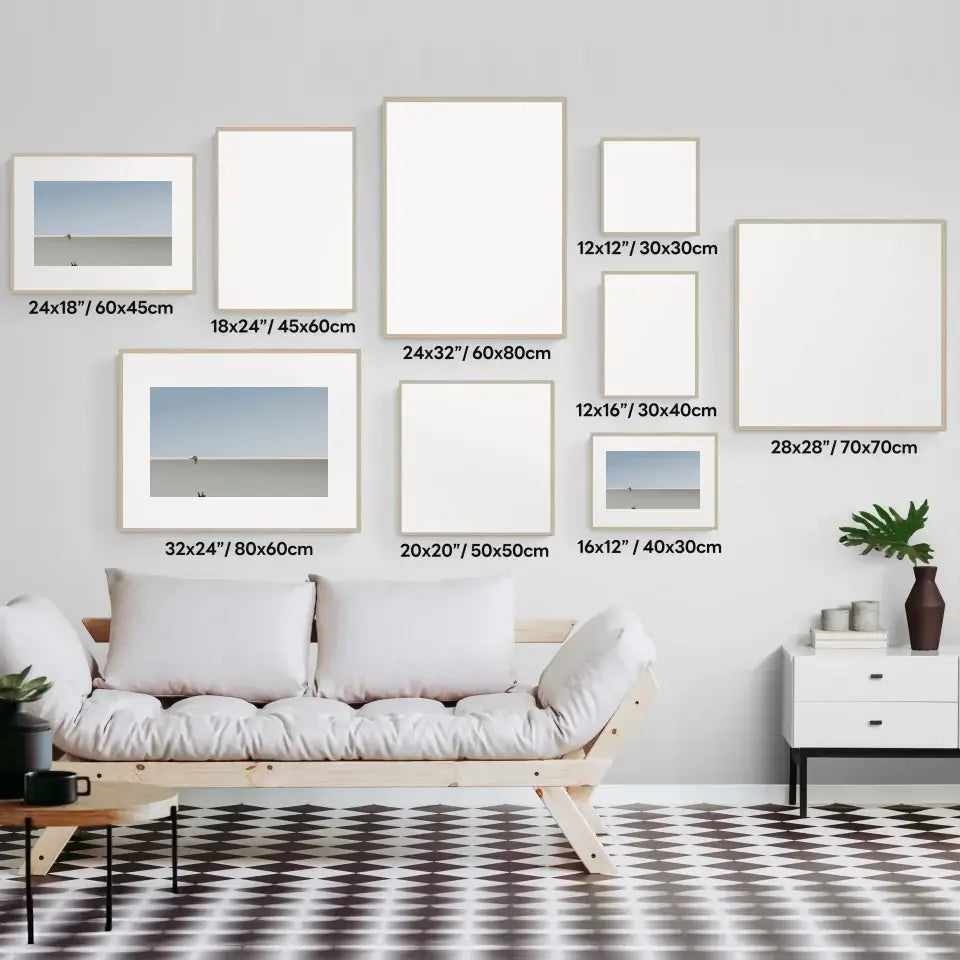 Gallery wall with various sized frames above a modern sofa in a stylish living room.