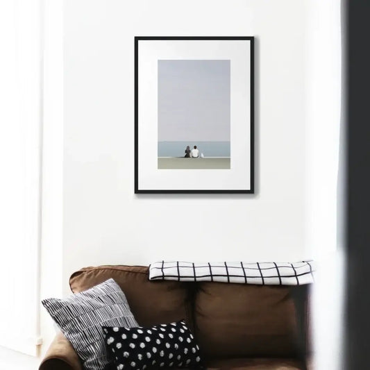 "Quiet Moments by the Sea art print on wall above brown sofa with patterned cushions"