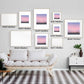 Gallery wall with various sizes of Silent Paws Before Sunset art prints above a sofa, showcasing tranquil twilight scenery.