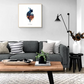 "Chicago cat silhouette watercolor artwork from Cityscape Cats series hanging in modern living room with gray couch and wooden table."