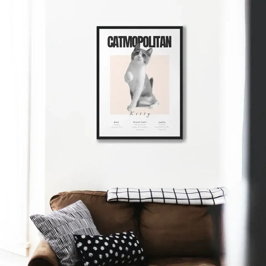 Personalized cat portrait titled 'Catmopolitan' hangs above a stylish couch, showcasing elegant feline art in a modern setting.