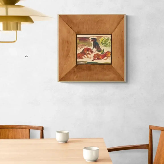 Framed print of three vibrant dogs in motion, by Arnold Peter Weisz-Kubincan, displayed on a dining room wall.