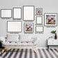 "Gallery wall with various frame sizes showcasing dog watercolor paintings with butterflies, aligned above a modern white sofa."