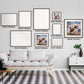 Gallery of framed personalized dog watercolor paintings in various sizes displayed above a cozy white sofa.