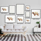 Wall display of multiple framed "Cheers with a Charming Dachshund" art prints in various sizes above a modern sofa.